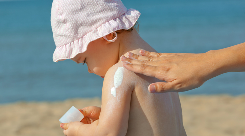 bebe en la playa con proteccion solar