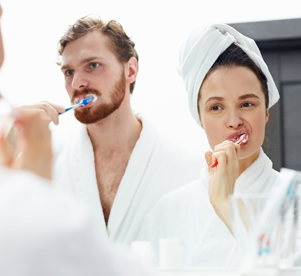 pareja lavandose los dientes en el baño